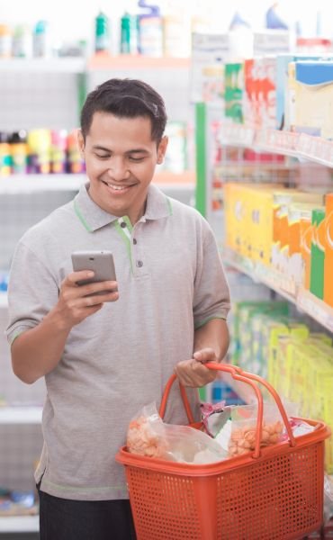 homre con su telefono en supermercado