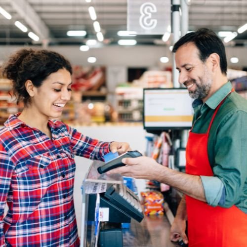 mujer pagando su mercado a vendedor